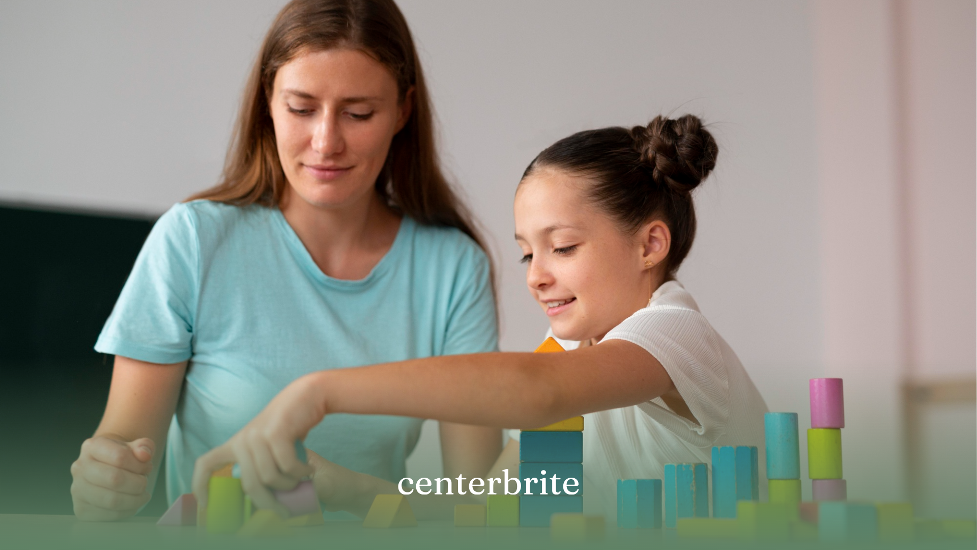 An ABA therapist and a kid with mild autism playing with building blocks during ABA therapy